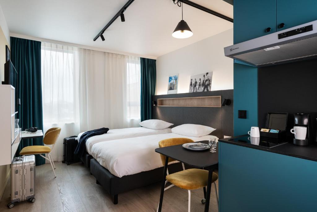 Habitación de hotel con cama y mesa en Adagio Access Gent Centrum Dampoort, en Gante