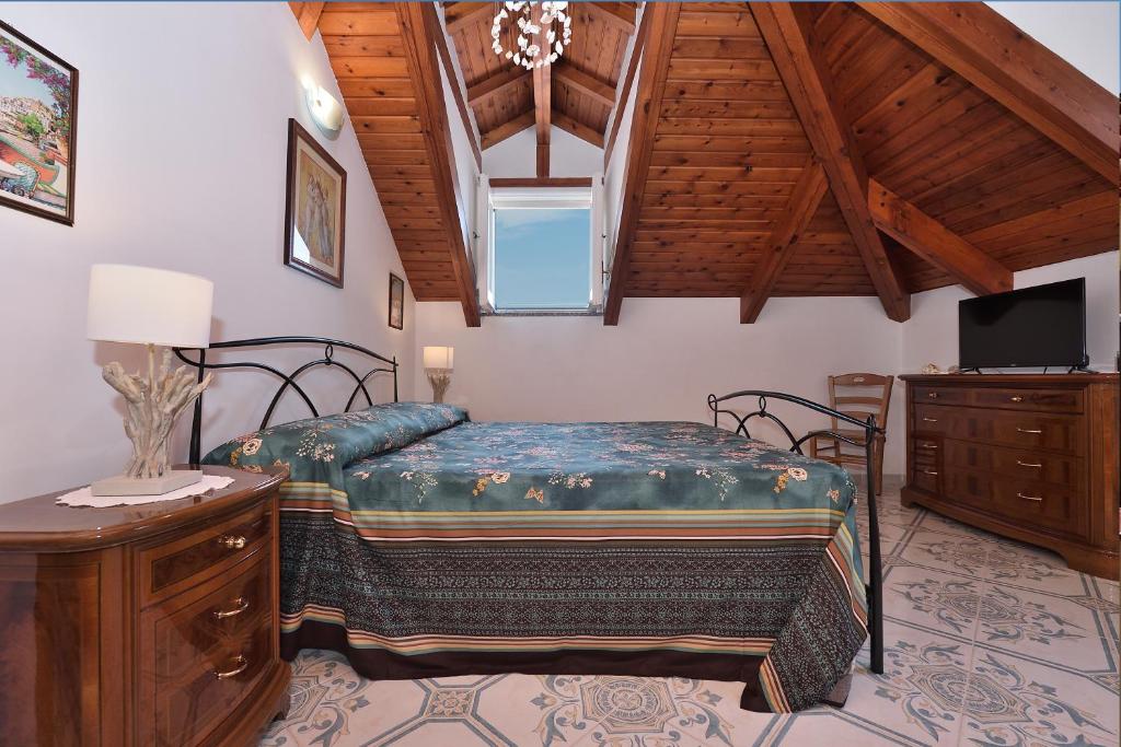 sypialnia z łóżkiem i telewizorem w pokoju w obiekcie Luna Rossa w mieście Minori