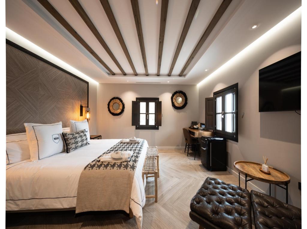 a hotel room with a large bed and a table at Hotel Santo Crist La Ciudadela Marbella in Marbella