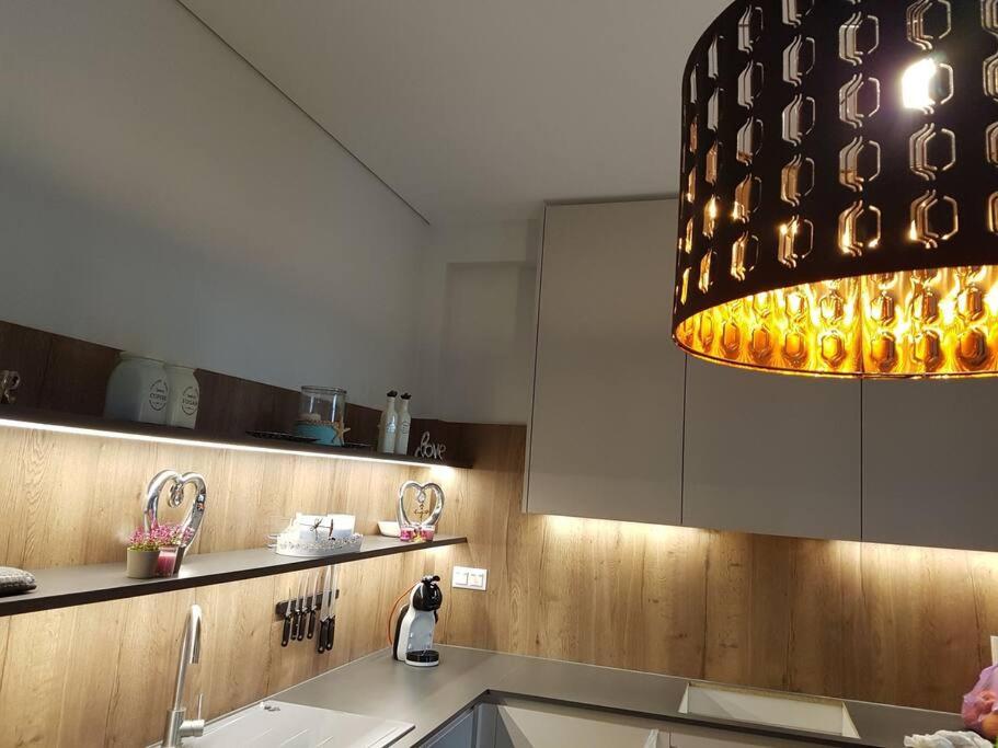 a kitchen with a sink and a large light fixture at EP Luxury Olea Valley Apartment in Nikiti
