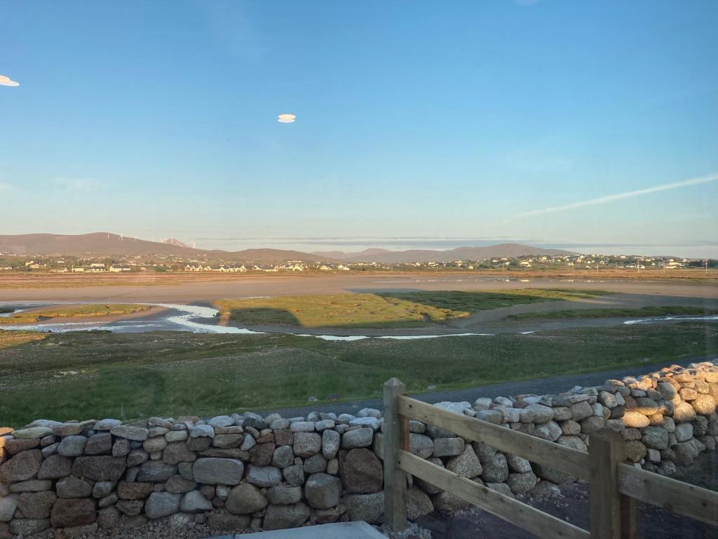 een uitzicht op een veld met een hek en een stenen muur bij Donegal Luxury Pods in Gweedore