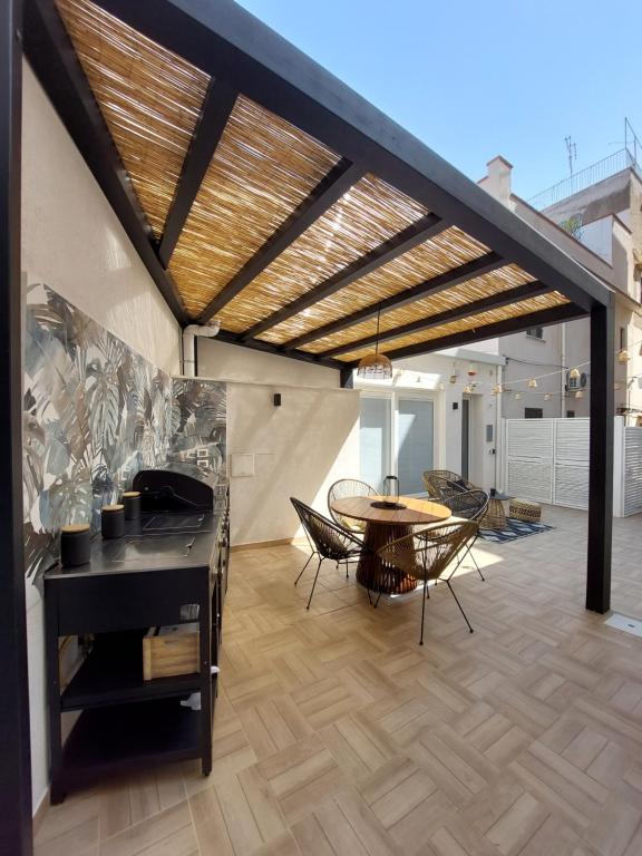 een patio met een tafel en stoelen en een houten vloer bij Curtigghiu Mondello in Mondello