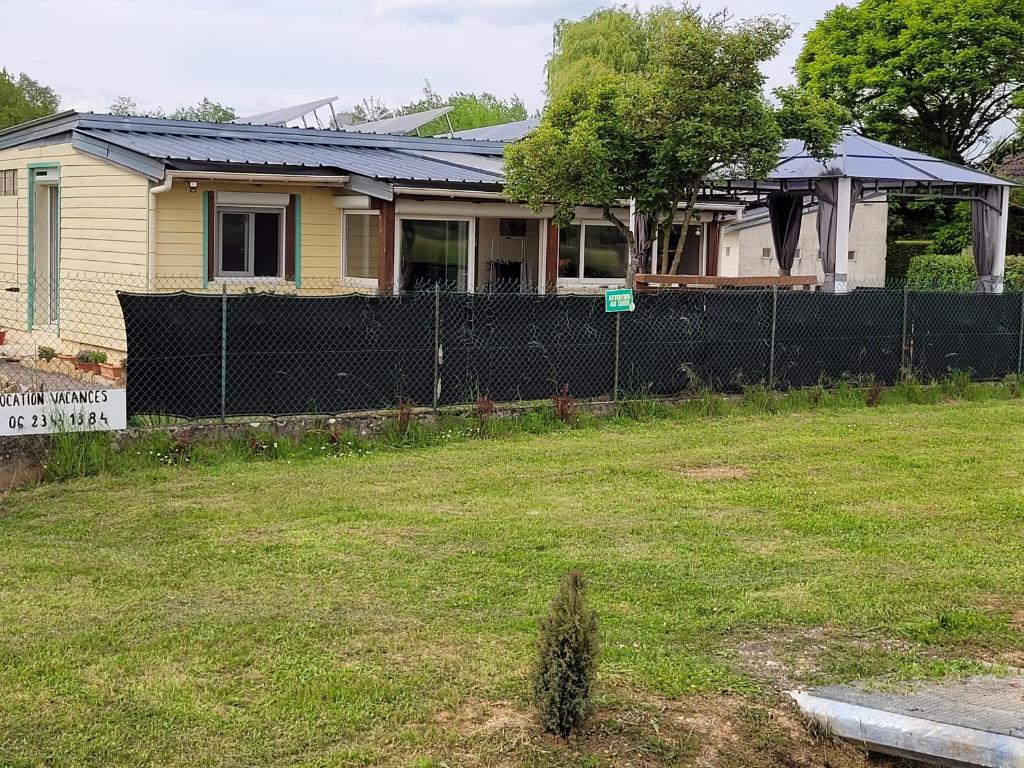 una casa con una recinzione in un cortile di Maison au bord du canal 