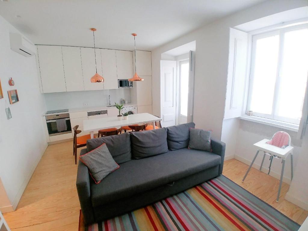 a living room with a couch and a kitchen at Be Local - 2 bedrooms in front of the Fado Museum in Alfama in Lisbon