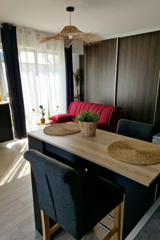 un salon avec une table et un canapé rouge dans l'établissement Studio Guérande, à Guérande