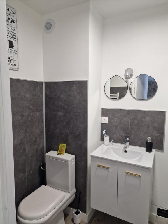 La salle de bains blanche est pourvue de toilettes et d'un lavabo. dans l'établissement Studio Guérande, à Guérande