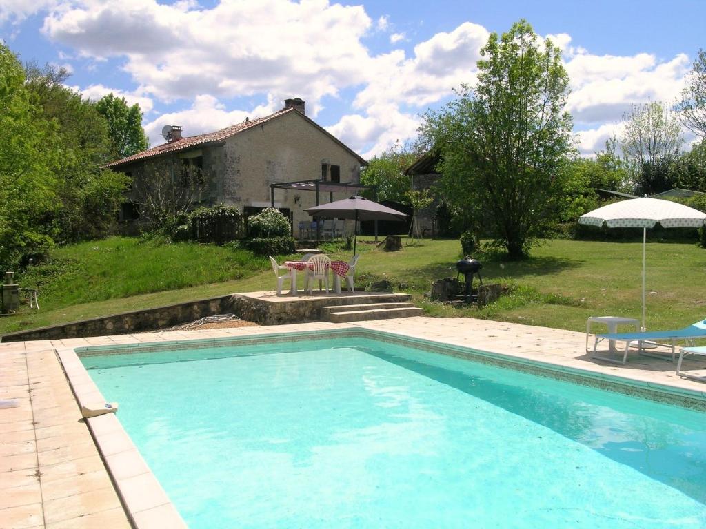 una piscina frente a una casa en Totally Secluded Stone Cottage with Private Pool, 2 acres of Garden and Woodland, en Paussac-et-Saint-Vivien