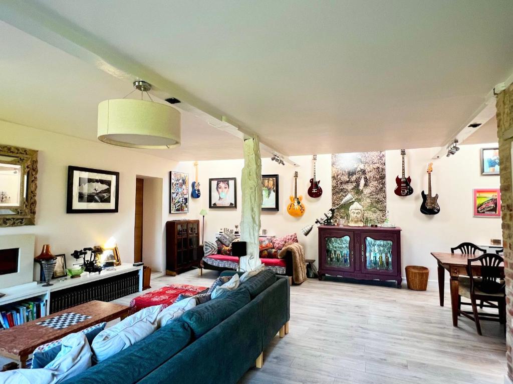 uma sala de estar com um sofá e uma mesa em Quirky Luxury Barn Sleeps 8, Pet Friendly em Calne