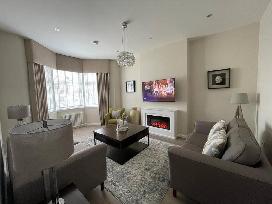 a living room with a couch and a fireplace at Luxury 2 Bedroom Cottage in West Calder