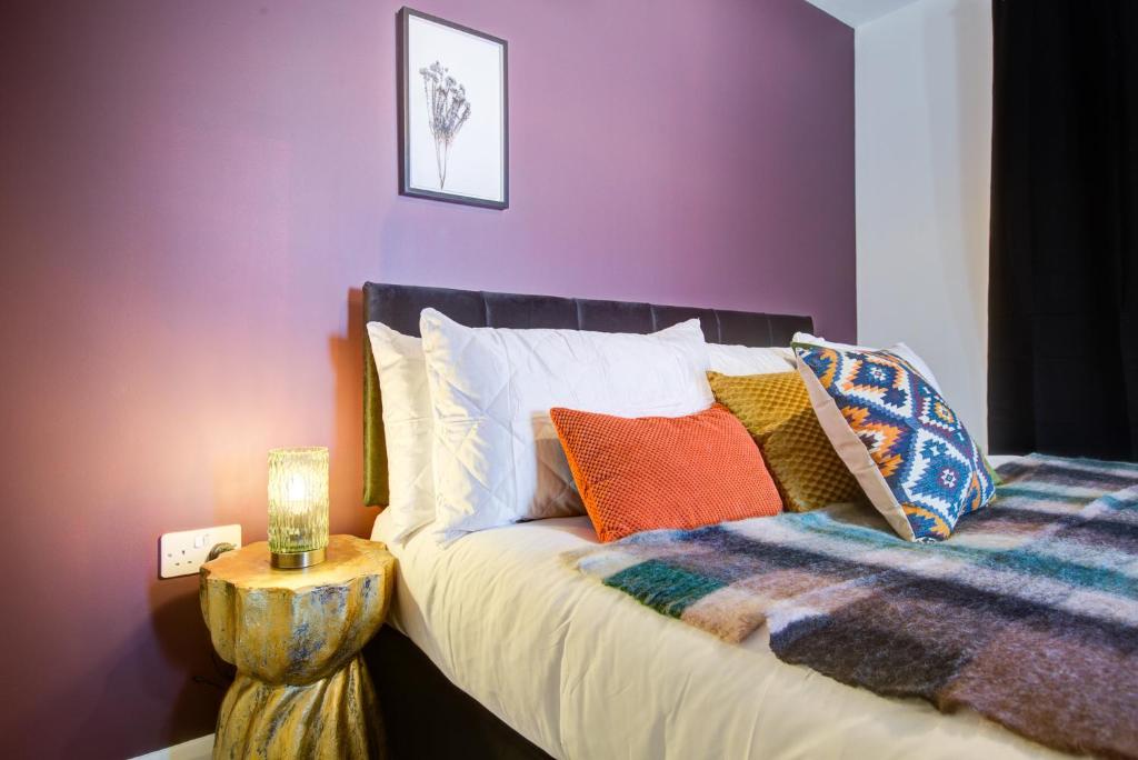 een slaapkamer met een bed met kleurrijke kussens bij 2 Bedroom 2 Bathroom in ASHFORD - Next to Station - Perfect for 6 people - Parking & Super Fast Internet in Ashford