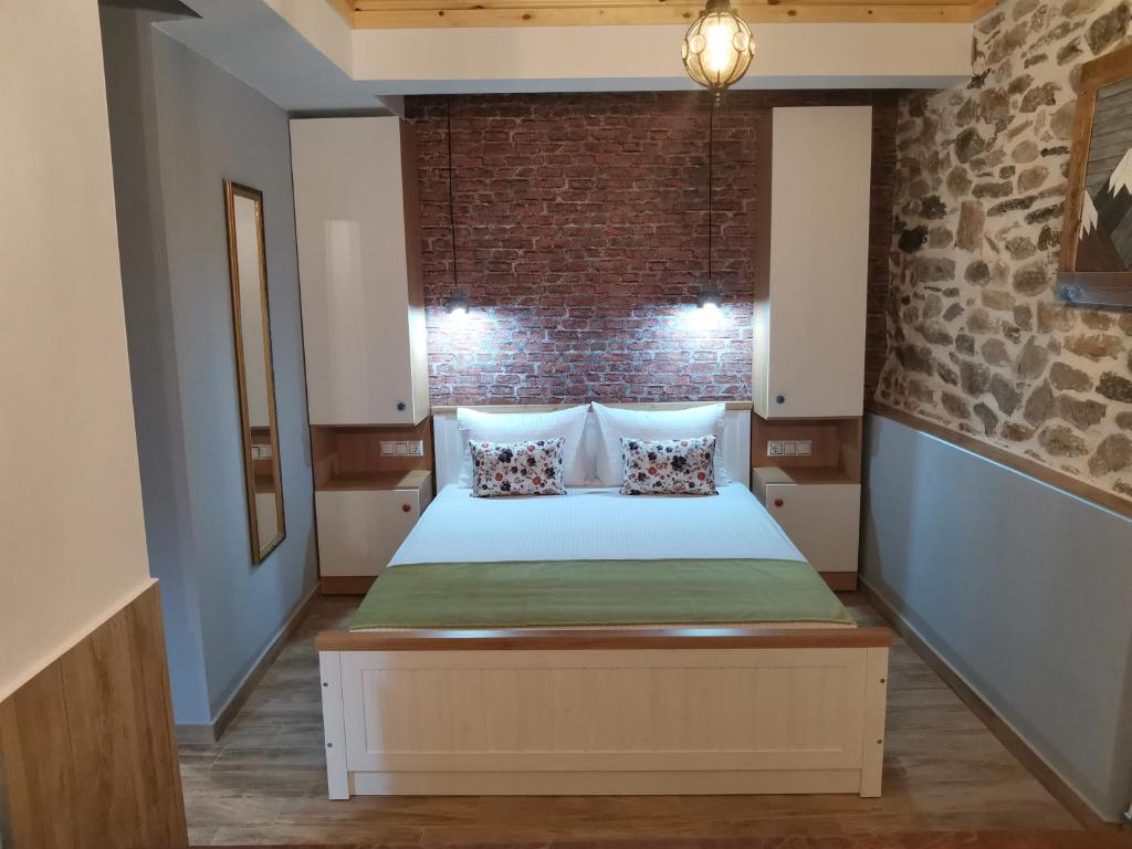 a bedroom with a bed with a brick wall at Kalderimi Studio in Sotír