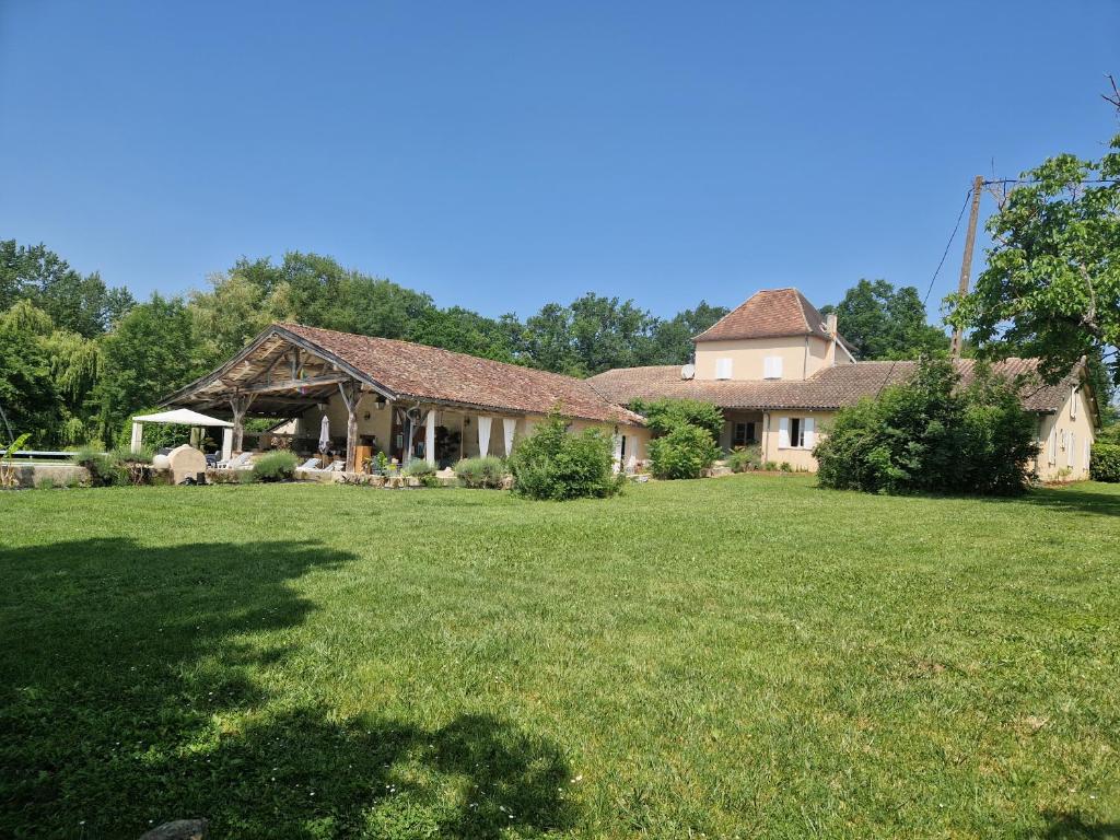 a house with a large yard with a green lawn at Maison Cassin47 in Lavergne