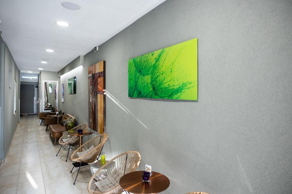 奧林匹亞基·阿克蒂的住宿－R&M STUDIOS，餐厅设有桌椅,墙上挂有绘画作品