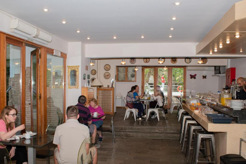 a group of people sitting at tables in a restaurant at Stefanakis Hotel & Apartments in Varkiza