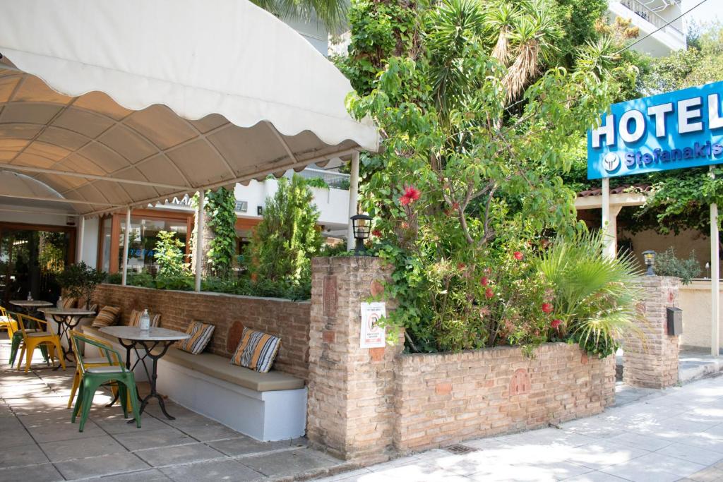 a restaurant with a table and chairs and an umbrella at Stefanakis Hotel & Apartments in Varkiza