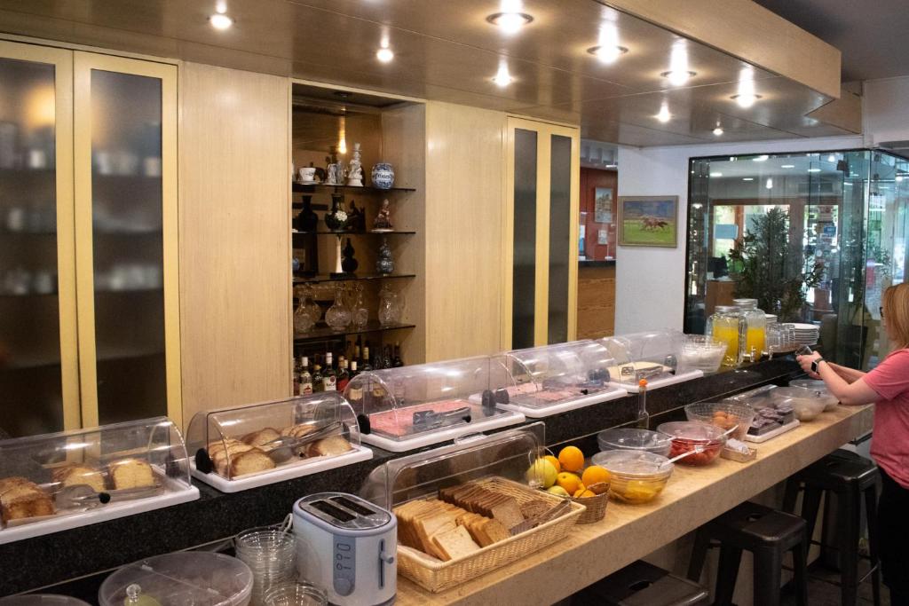 a woman standing in front of a buffet line with food at Stefanakis Hotel & Apartments in Varkiza