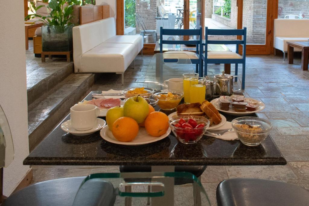 a table with a tray of fruit and breakfast foods at Stefanakis Hotel & Apartments in Varkiza
