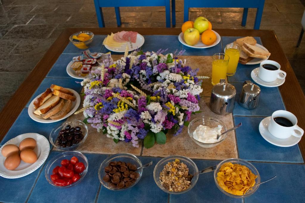 a table with breakfast foods and drinks on it at Stefanakis Hotel & Apartments in Varkiza