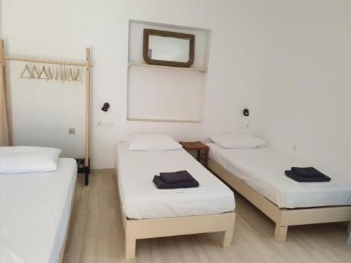two beds in a room with a mirror and a mirror at Zinas pension in Ios Chora