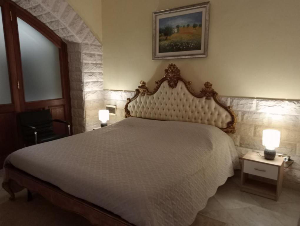 a bedroom with a large white bed with two lamps at Appartamento Centrale in Molfetta