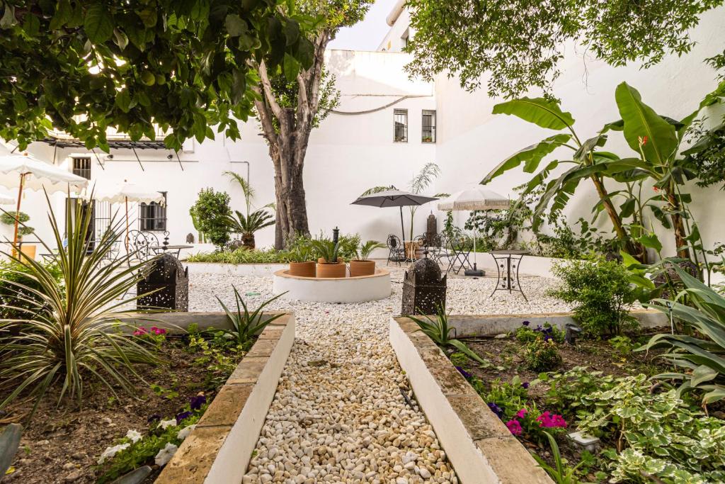 a garden in a white building with plants at Casa Palacio Rufina & Jardines in Jerez de la Frontera