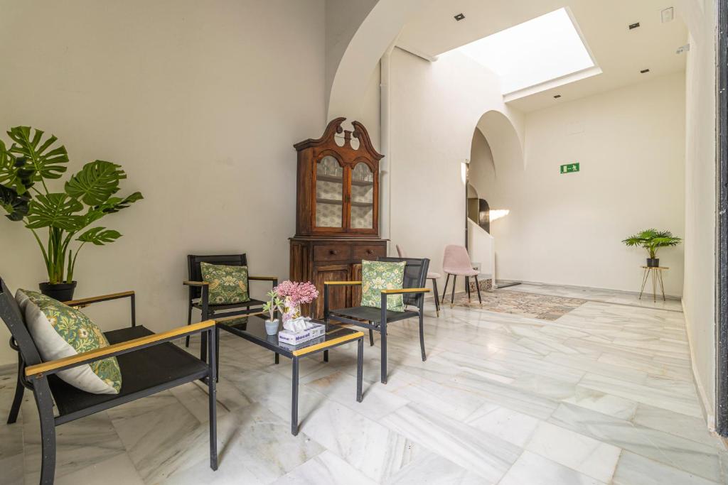 a living room with chairs and tables and a skylight at Casa Palacio Rufina & Jardines in Jerez de la Frontera