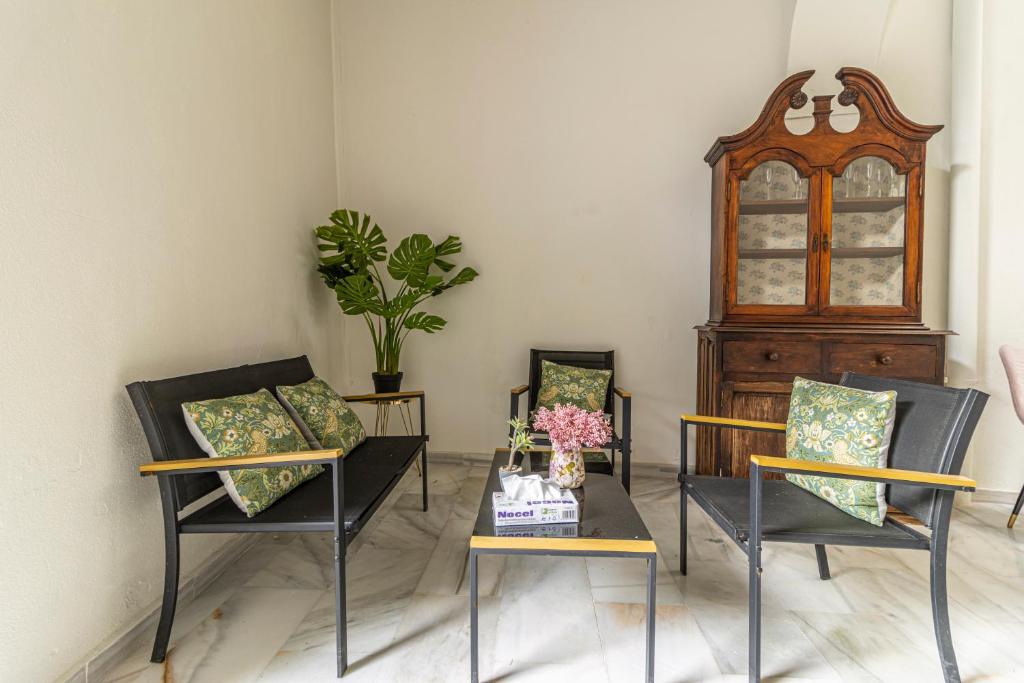 a room with two chairs and a table with flowers at Casa Palacio Rufina & Jardines in Jerez de la Frontera