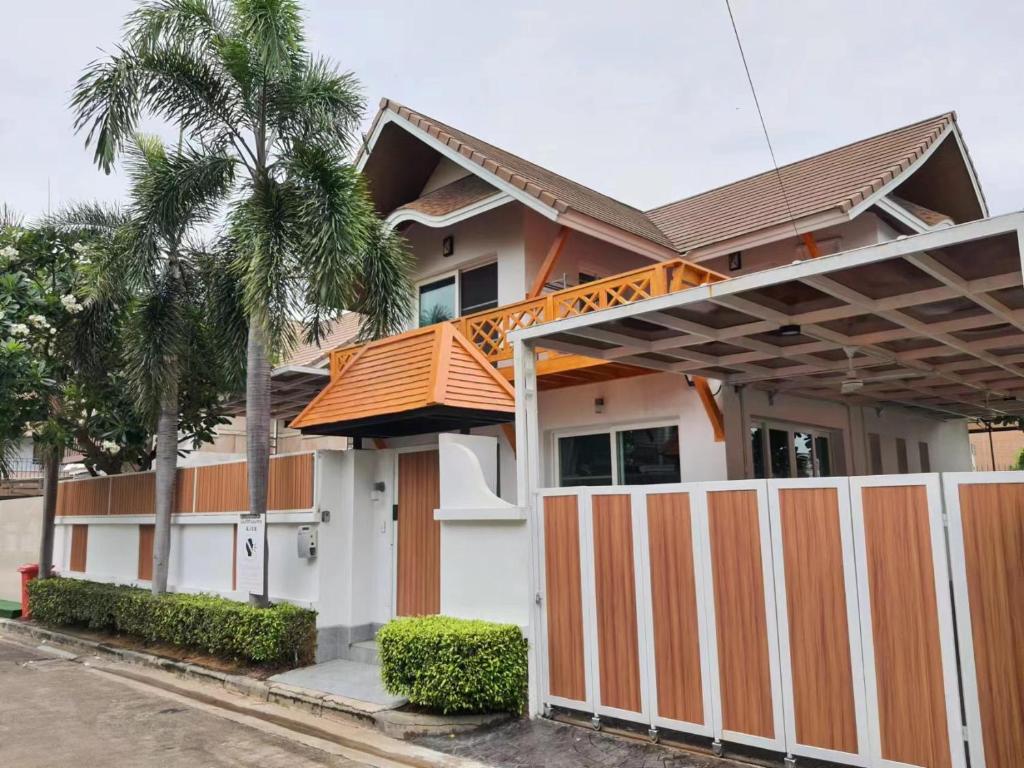 uma casa com uma cerca laranja e branca em 芭提雅市中心4间卧室泳池别墅好莱坞Hollywood旁-19 em Pattaya Central