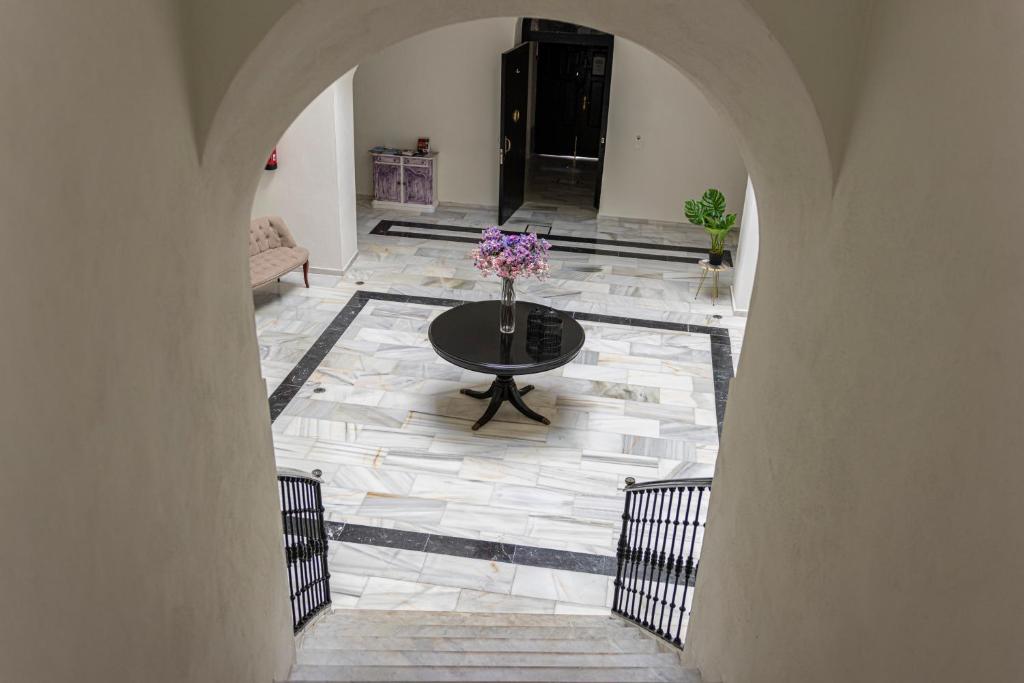 a room with a table with flowers on the floor at Casa Palacio Rufina & Jardines in Jerez de la Frontera
