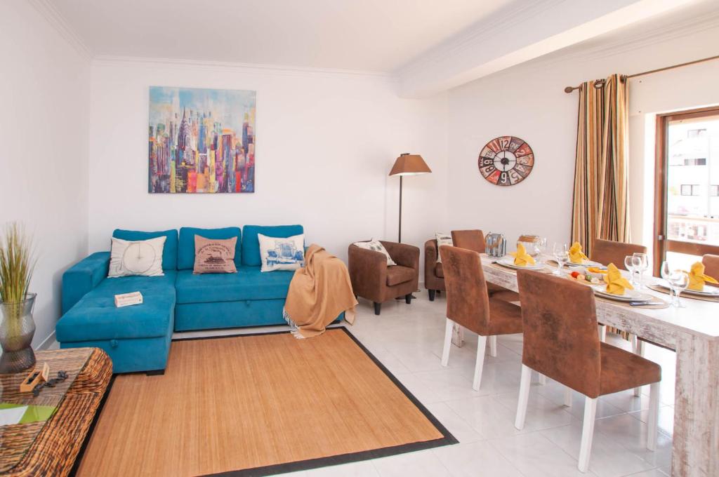 a living room with a blue couch and a table at Waves by OCvillas in Albufeira