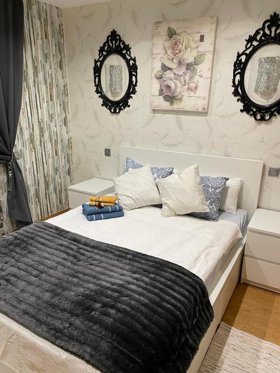 een slaapkamer met een groot bed en 2 spiegels bij Cozy Flat in Barcelona