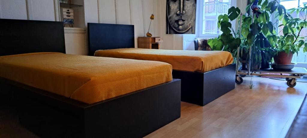 two beds with orange covers in a room at La Vie Eau Naturelle in Sembrancher