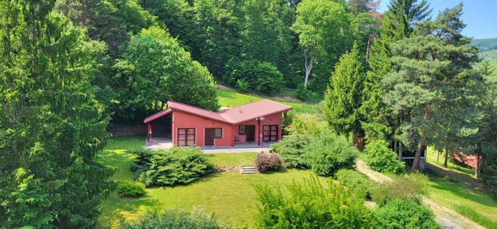 ein kleines rotes Haus inmitten eines Gartens in der Unterkunft APARTMÁNY SMRAĎAVKA č.ev.52 in Buchlovice