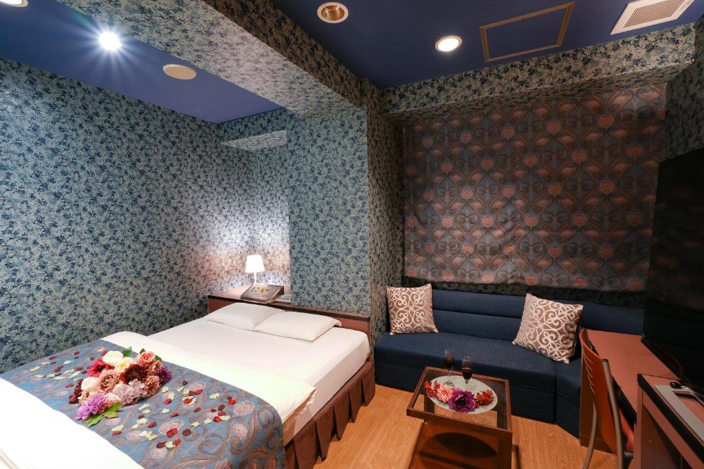 pokój hotelowy z łóżkiem i kanapą w obiekcie Hotel Jupiter (Adult Only) w mieście Hiroszima