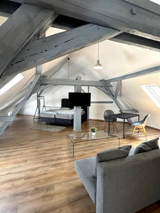 a living room with a couch and a bed in a attic at Strahlende Wohlfühloase in Marktheidenfeld