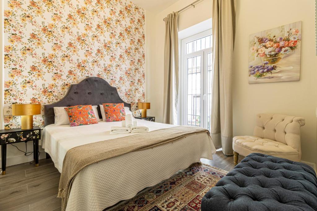 a bedroom with a large bed and a window at Casa Palacio Rufina & Jardines in Jerez de la Frontera