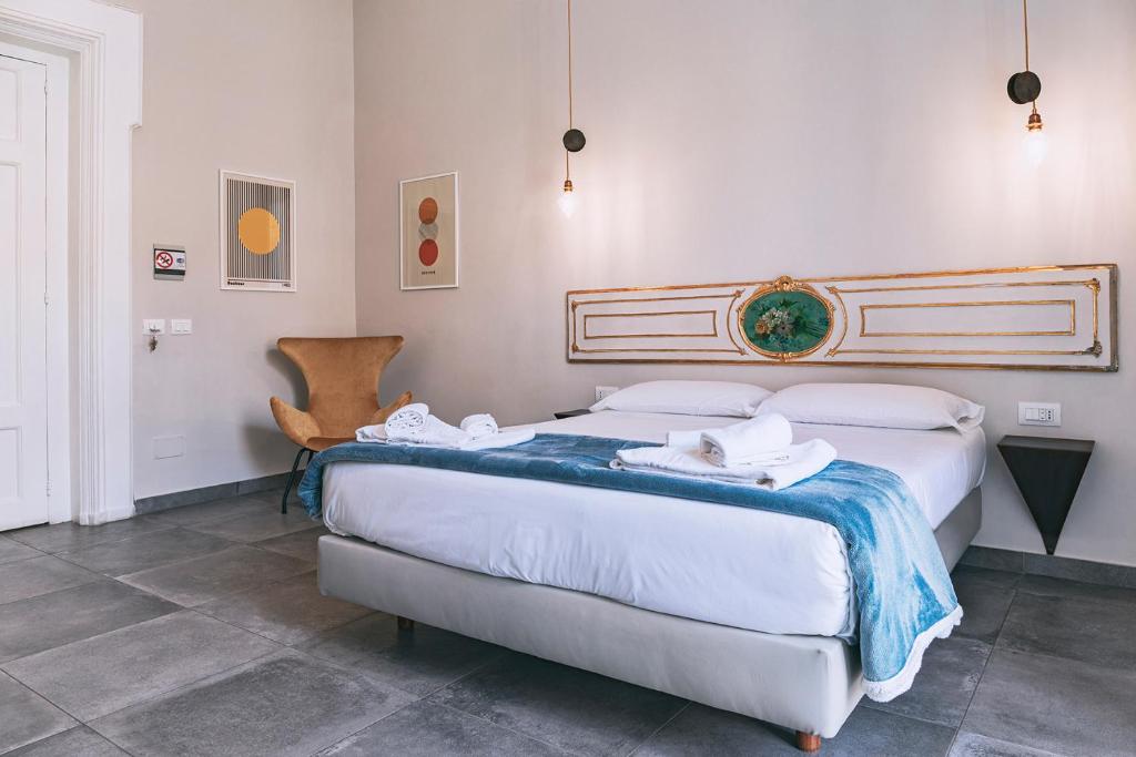 um quarto com 2 camas e uma cadeira em La Smorfia em Nápoles