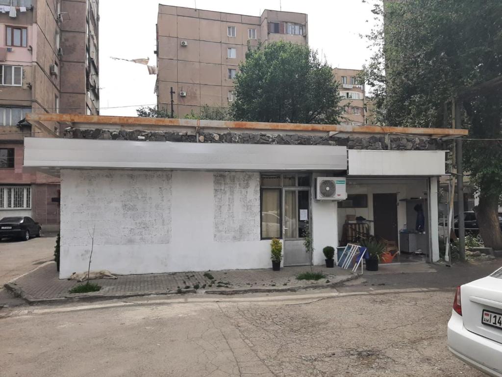 een klein wit gebouw aan de straatkant bij Vahe’s family guests house in Jerevan