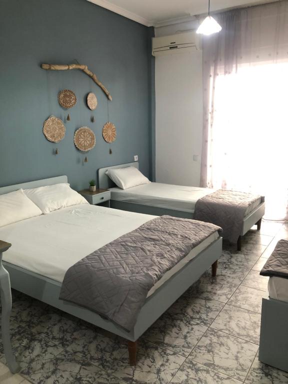 a bedroom with two beds and a blue wall at Olympus Apartments in Paralia Katerinis