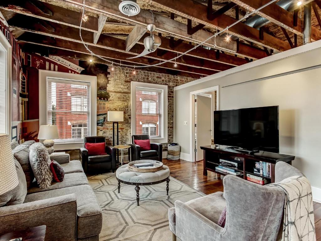 sala de estar con muebles y TV de pantalla plana. en Broughton Corner Loft en Savannah