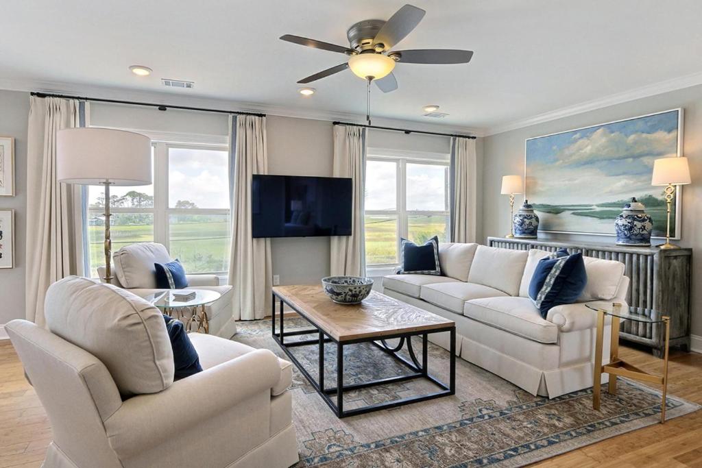 a living room with white furniture and a flat screen tv at El Rey Collection 2 in Tybee Island