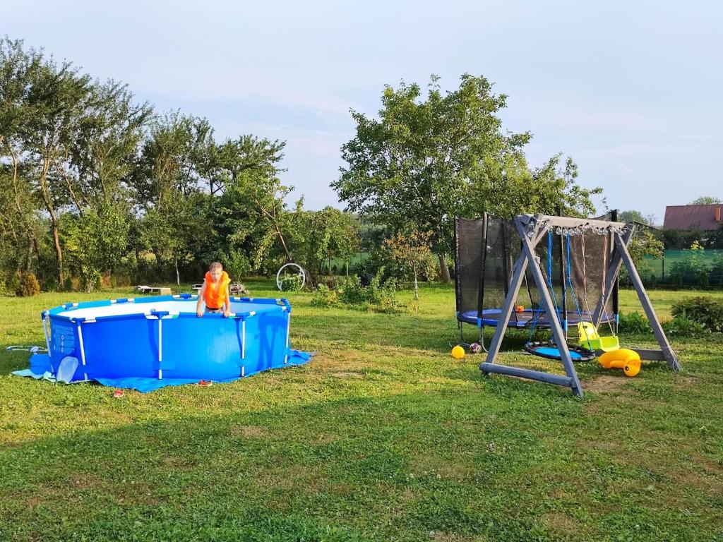 a man is standing next to a play set at Apartament Domowe Zacisze 1 in Choczewo
