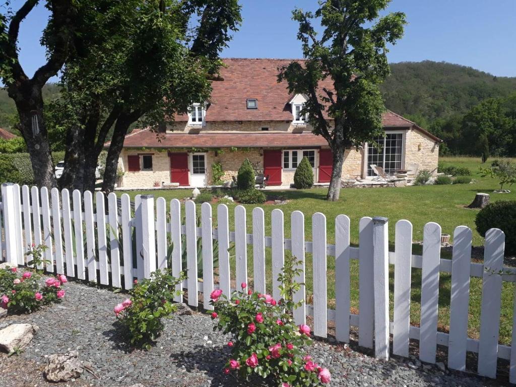 a white picket fence in front of a house at La bergerie de Laura in Vaillac