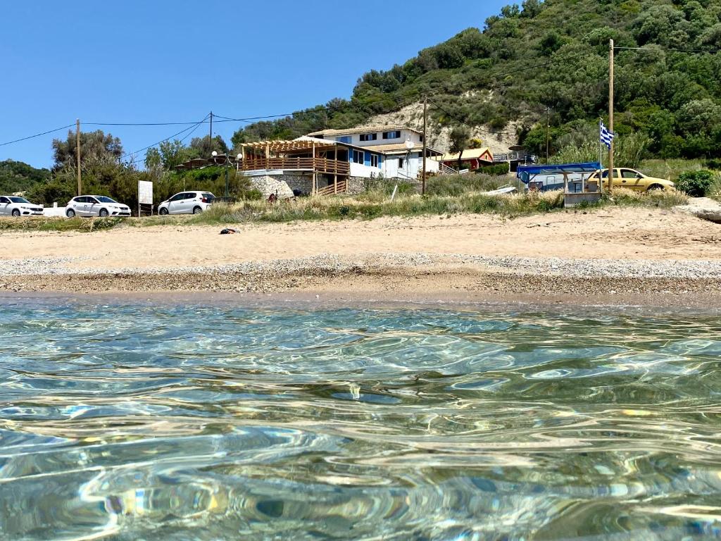 een waterlichaam met een strand en huizen bij Hamre Apartments (Nicholas) in Agios Georgios Pagon
