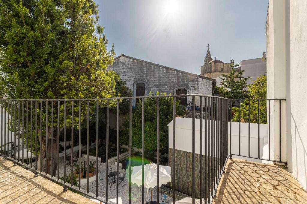 a metal fence with a swimming pool behind it at Casa Palacio Rufina & Jardines in Jerez de la Frontera