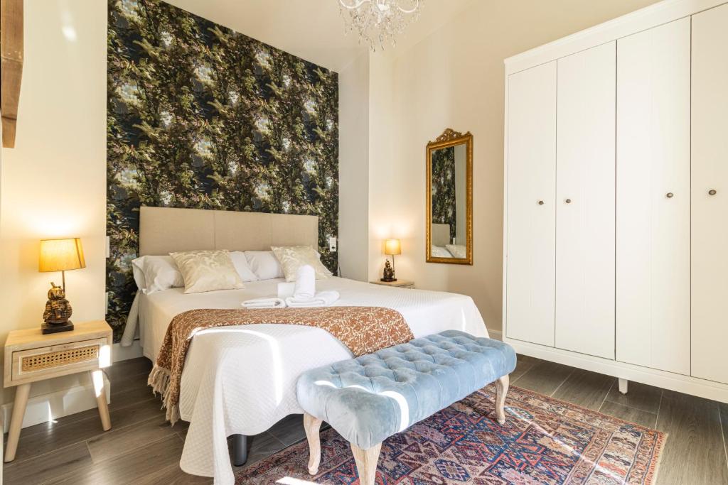 a bedroom with a bed and a large wall at Casa Palacio Rufina & Jardines in Jerez de la Frontera