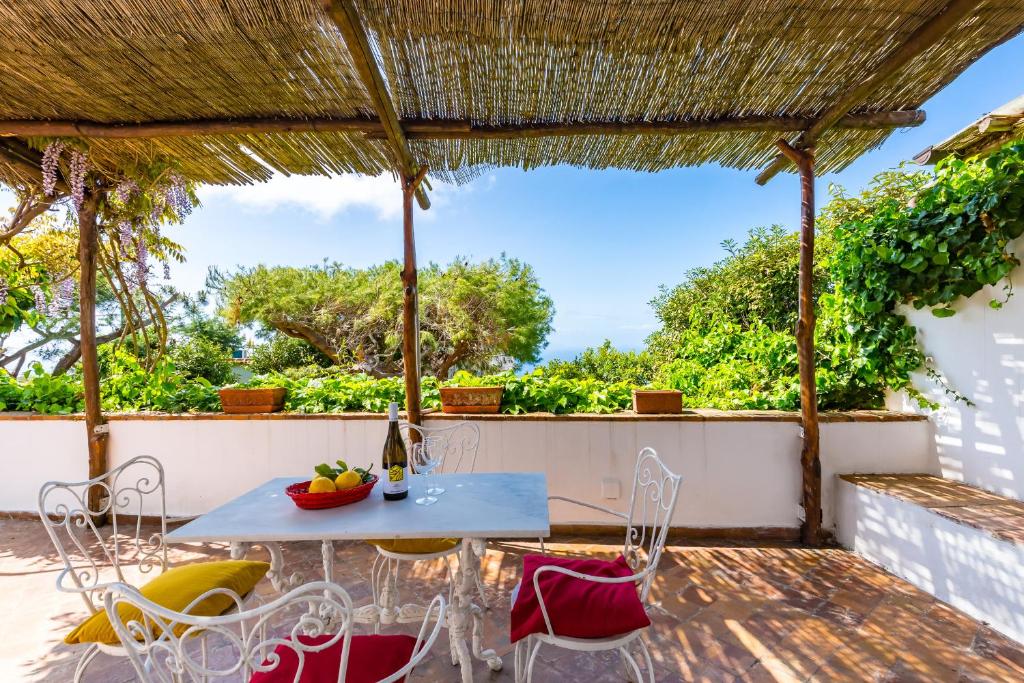 un tavolo e sedie su un patio con vista di Villa delle Ninfee by Napoliapartments ad Anacapri