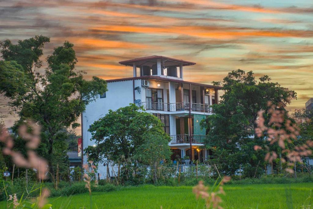 un edificio con porche en la parte superior de un campo en Hotel Janara, en Kurunegala
