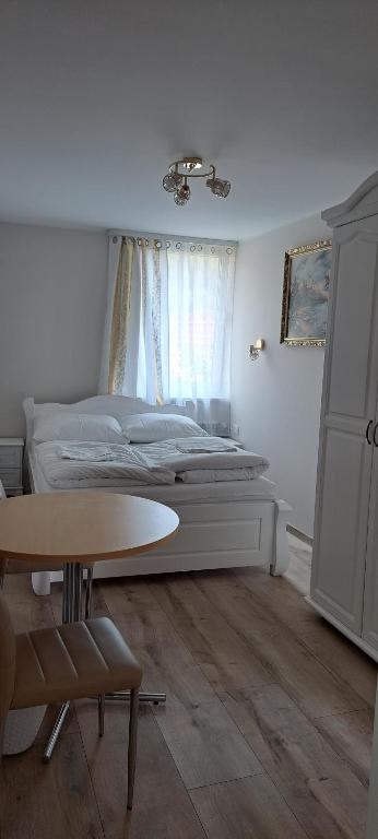 a bedroom with a bed and a table in front of a window at Magurka in Rycerka Górna