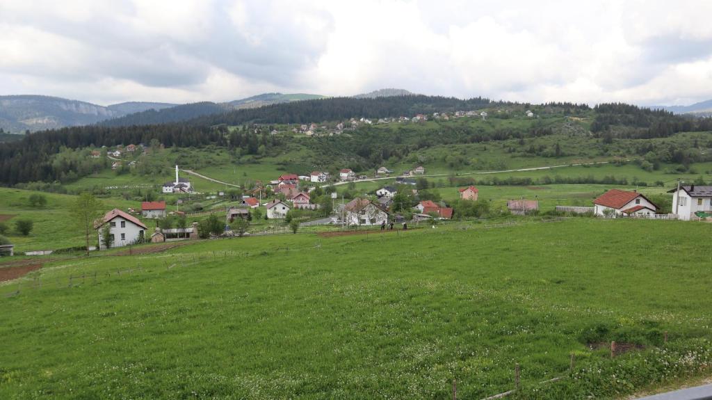 a large green field with houses on a hill at Lotus Villas in Travnik